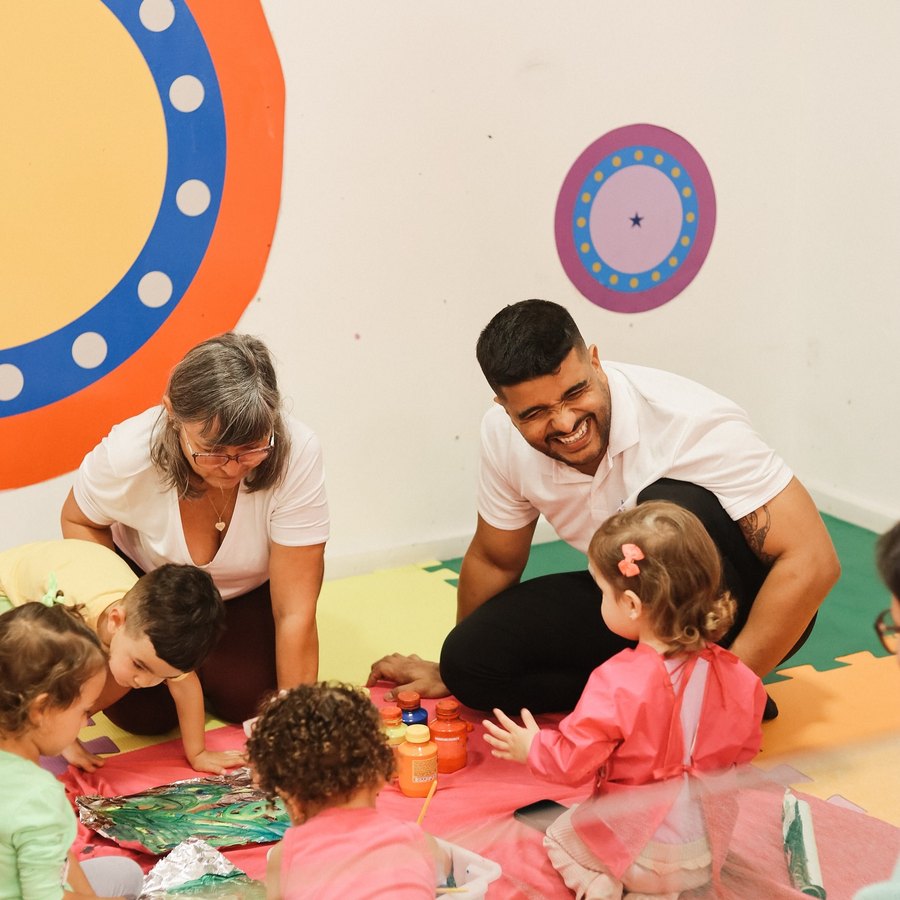 Crianças em atividade de pintura sensorial acompanhadas pelos professores da Baby Gym